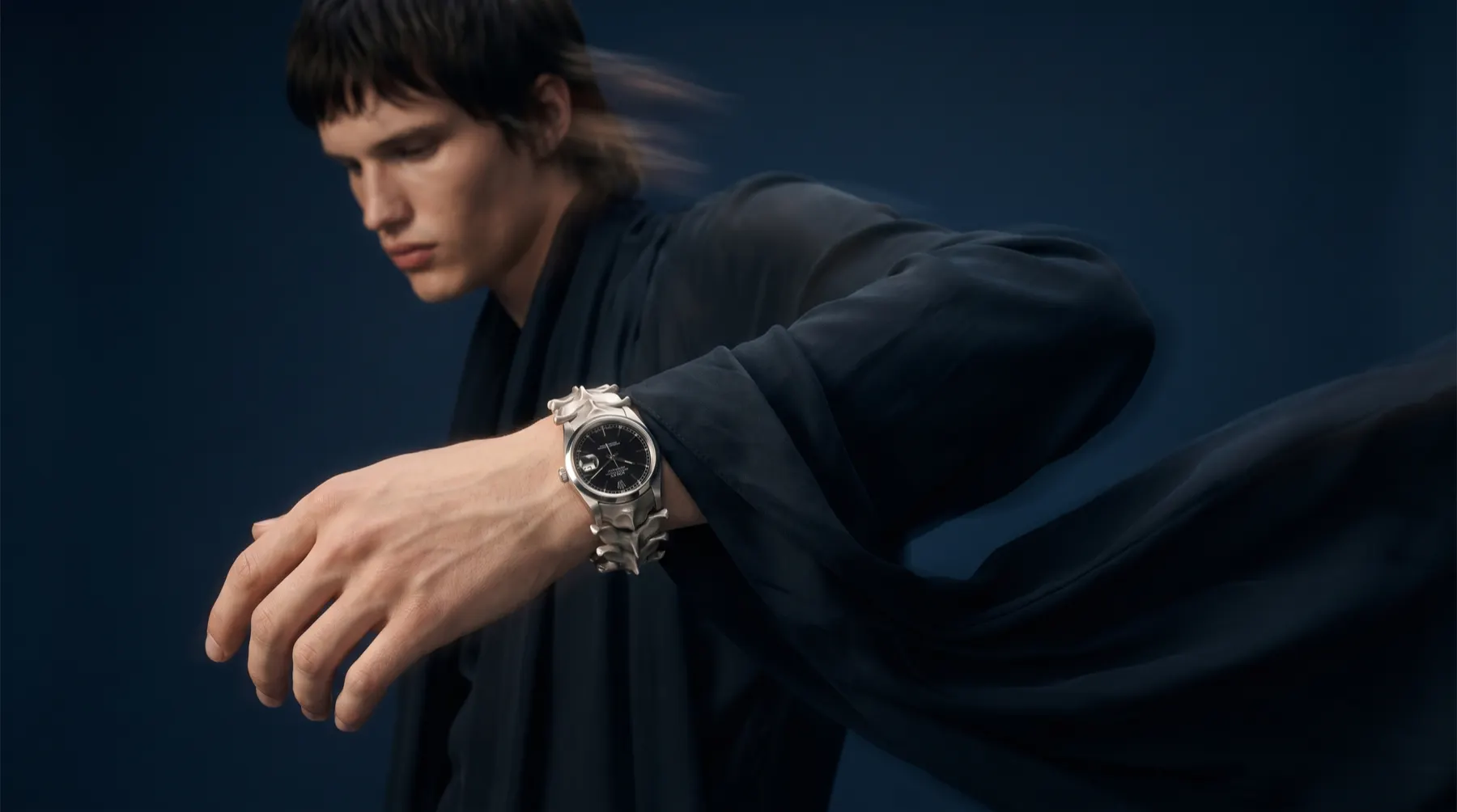 Fashion motion study with sculptural watch on wrist